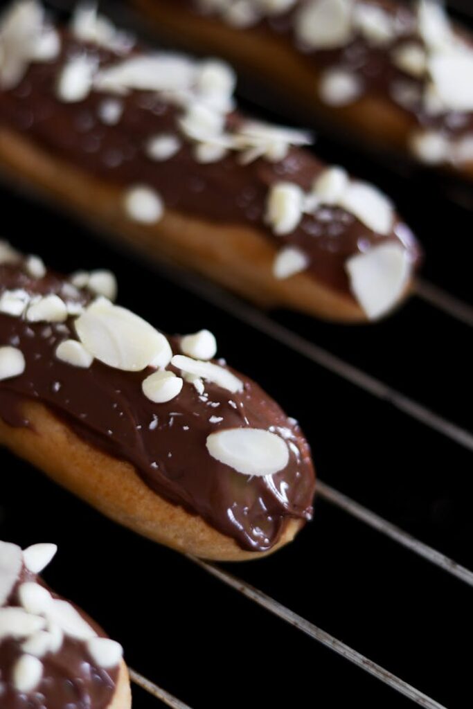 Delicious chocolate eclairs topped with almond flakes, perfect for dessert lovers.