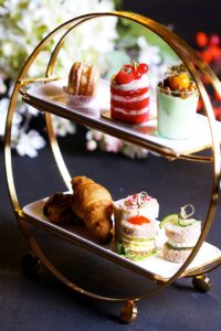 Luxurious assortment of pastries and sweets on a tiered stand, perfect for high tea events.